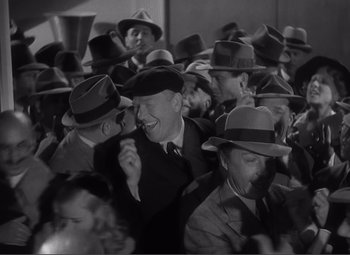 Movie still from “Sullivan's Travels” (1941), directed by Preston Sturges – A group of men wearing hats and smiling for the camera; Medium shot, High angle
