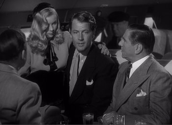 Movie still from “Sullivan's Travels” (1941), directed by Preston Sturges – A group of people sitting around a table; Medium shot, Over the shoulder angle