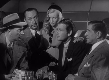 Movie still from “Sullivan's Travels” (1941), directed by Preston Sturges – A black and white photo of a group of men and a woman; Medium shot, High angle