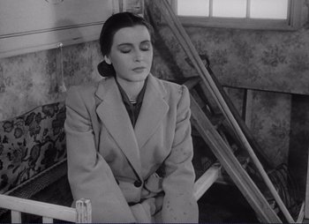 Movie still from “Summer Interlude” (1951), directed by Ingmar Bergman – A black and white photo of a woman sitting on a chair; Medium shot, High angle