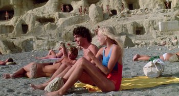 Movie still from “Summer Lovers” (1982), directed by Randal Kleiser – A group of people sitting on the beach; Wide shot, High angle