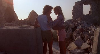 Movie still from “Summer Lovers” (1982), directed by Randal Kleiser – A man and a woman standing next to each other; Medium shot, Low angle