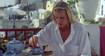 Movie still from “Summer Lovers” (1982), directed by Randal Kleiser – A woman in white shirt cutting a cake; Medium shot, Low angle