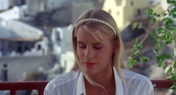 Movie still from “Summer Lovers” (1982), directed by Randal Kleiser – A woman wearing a white shirt and a white headband; Close Up shot, High angle
