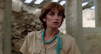 Movie still from “Summer Lovers” (1982), directed by Randal Kleiser – A person wearing a shirt and a necklace; Close Up shot, Over the shoulder angle