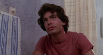 Movie still from “Summer Lovers” (1982), directed by Randal Kleiser – A young man looking up into the air; Close Up shot, Low angle