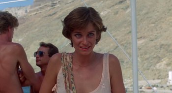 Movie still from “Summer Lovers” (1982), directed by Randal Kleiser – A person wearing a white shirt; Close Up shot, Over the shoulder angle