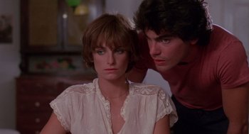 Movie still from “Summer Lovers” (1982), directed by Randal Kleiser – A woman sitting next to a man in front of a window; Close Up shot, Low angle