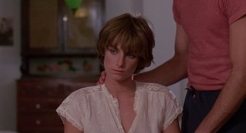 Movie still from “Summer Lovers” (1982), directed by Randal Kleiser – A woman in a white shirt is getting her hair combed; Close Up shot, Over the shoulder angle