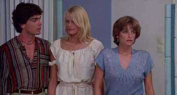 Movie still from “Summer Lovers” (1982), directed by Randal Kleiser – A group of people standing next to each other in a room; Medium shot, Low angle