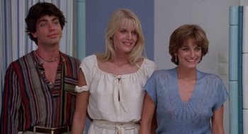 Movie still from “Summer Lovers” (1982), directed by Randal Kleiser – A group of people standing next to each other in a room; Medium shot, Low angle