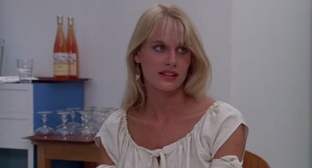 Movie still from “Summer Lovers” (1982), directed by Randal Kleiser – A woman with blonde hair wearing a white blouse; Close Up shot, Over the shoulder angle