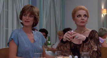 Movie still from “Summer Lovers” (1982), directed by Randal Kleiser – A couple of women sitting at a dinner table together; Close Up shot, Low angle