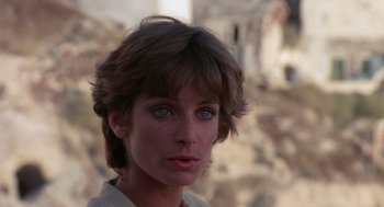 Movie still from “Summer Lovers” (1982), directed by Randal Kleiser – A person with short brown hair; Close Up shot, Over the shoulder angle