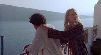 Movie still from “Summer Lovers” (1982), directed by Randal Kleiser – A woman and a man standing next to each other near a body of water; Medium shot, Over the shoulder angle