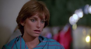 Movie still from “Summer Lovers” (1982), directed by Randal Kleiser – A person wearing a blue shirt; Close Up shot, Over the shoulder angle