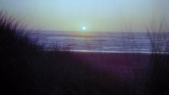 Movie still from “Summer of '42” (1971), directed by Robert Mulligan – The sun is setting over the ocean on the beach; Extreme Wide shot, Low angle
