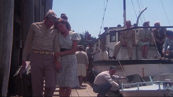 Movie still from “Summer of '42” (1971), directed by Robert Mulligan – A man and a woman standing next to a boat; Wide shot, Low angle