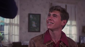 Movie still from “Summer of '42” (1971), directed by Robert Mulligan – A young man in a brown jacket smiling; Close Up shot, Low angle