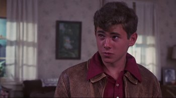 Movie still from “Summer of '42” (1971), directed by Robert Mulligan – A young man wearing a leather jacket looking to his left; Close Up shot, Over the shoulder angle