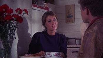 Movie still from “Summer of '42” (1971), directed by Robert Mulligan – A woman sitting at a table holding a bowl; Medium shot, Over the shoulder angle
