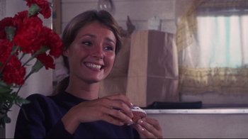 Movie still from “Summer of '42” (1971), directed by Robert Mulligan – A woman holding a doughnut in her hands; Close Up shot, Over the shoulder angle