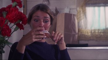 Movie still from “Summer of '42” (1971), directed by Robert Mulligan – A woman eating a donut in front of a mirror; Close Up shot, High angle