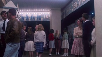 Movie still from “Summer of '42” (1971), directed by Robert Mulligan – A group of young girls standing in front of a building; Wide shot, High angle