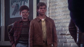 Movie still from “Summer of '42” (1971), directed by Robert Mulligan – Two young men standing next to each other in front of a brick wall; Medium shot, Low angle