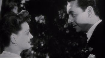 Movie still from “Summer of '42” (1971), directed by Robert Mulligan – A man and a woman looking at each other in front of trees; Close Up shot, Low angle