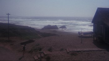 Movie still from “Summer of '42” (1971), directed by Robert Mulligan – A person standing on the beach looking out at the ocean; Extreme Wide shot, High angle