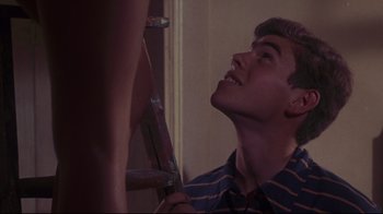 Movie still from “Summer of '42” (1971), directed by Robert Mulligan – A man looking up at a ladder in a room; Medium shot, Low angle
