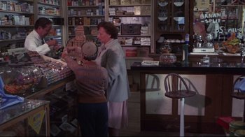 Movie still from “Summer of '42” (1971), directed by Robert Mulligan – Two women are standing in a store looking at items on the counter; Wide shot, High angle