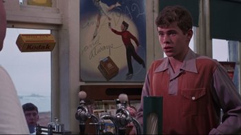 Movie still from “Summer of '42” (1971), directed by Robert Mulligan – A man standing in front of a picture of a boy; Medium shot, Over the shoulder angle