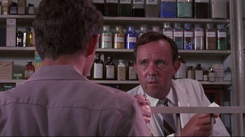 Movie still from “Summer of '42” (1971), directed by Robert Mulligan – A man in a white lab coat talking to another man in a lab coat; Medium shot, Over the shoulder angle