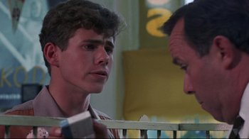 Movie still from “Summer of '42” (1971), directed by Robert Mulligan – A young man talking to an older man in front of a baby crib; Close Up shot, Over the shoulder angle
