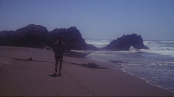 Movie still from “Summer of '42” (1971), directed by Robert Mulligan – A person walking on the beach near the water; Extreme Wide shot, High angle