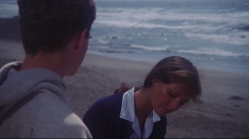 Movie still from “Summer of '42” (1971), directed by Robert Mulligan – A woman standing next to a man on a beach; Medium shot, Over the shoulder angle