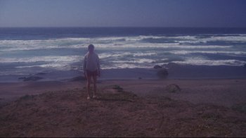 Movie still from “Summer of '42” (1971), directed by Robert Mulligan – A person standing on a beach near the ocean; Extreme Wide shot, High angle