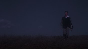 Movie still from “Summer of '42” (1971), directed by Robert Mulligan – A man walking on top of a grass covered hill; Wide shot, Low angle