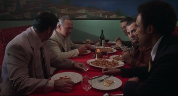 Movie still from “Summer of Sam” (1999), directed by Spike Lee – A group of people sitting at a table eating food; Wide shot, High angle