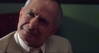 Movie still from “Summer of Sam” (1999), directed by Spike Lee – An older man wearing a suit and tie; Close Up shot, Low angle