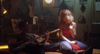 Movie still from “Summer of Sam” (1999), directed by Spike Lee – A man and a woman sitting on the floor with a guitar; Medium shot, Low angle