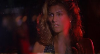 Movie still from “Summer of Sam” (1999), directed by Spike Lee – A beautiful woman with long brown hair wearing a silver dress; Close Up shot, Over the shoulder angle