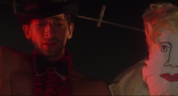 Movie still from “Summer of Sam” (1999), directed by Spike Lee – A person wearing a hat and bow tie; Close Up shot, Low angle