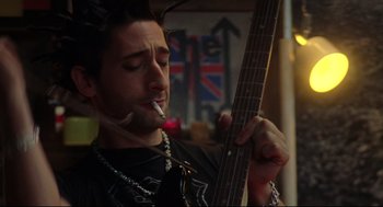 Movie still from “Summer of Sam” (1999), directed by Spike Lee – A man holding a guitar while smoking a cigarette; Close Up shot, Low angle