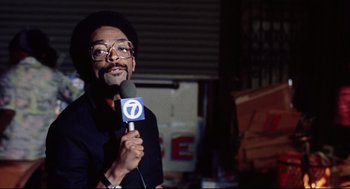 Movie still from “Summer of Sam” (1999), directed by Spike Lee – A man is holding a microphone while standing in front of a camera; Medium shot, Low angle
