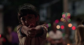 Movie still from “Summer of Sam” (1999), directed by Spike Lee – A young girl wearing glasses and a brown shirt points at the camera; Close Up shot, Over the shoulder angle