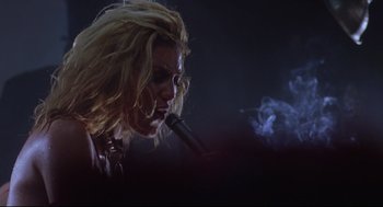Movie still from “Summer of Sam” (1999), directed by Spike Lee – A woman with long blonde hair is smoking a pipe; Close Up shot, Low angle