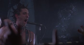 Movie still from “Summer of Sam” (1999), directed by Spike Lee – A man in a leather vest singing into a microphone; Close Up shot, Low angle